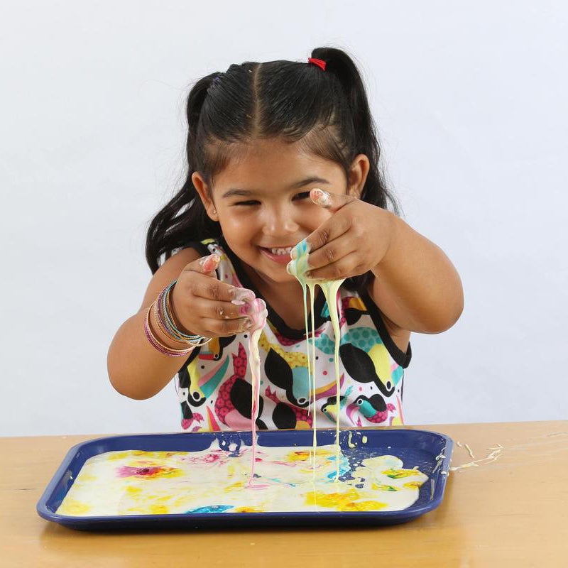 Little girl plays with colorful oobleck from the Crazy Colors Messy Play Kit.